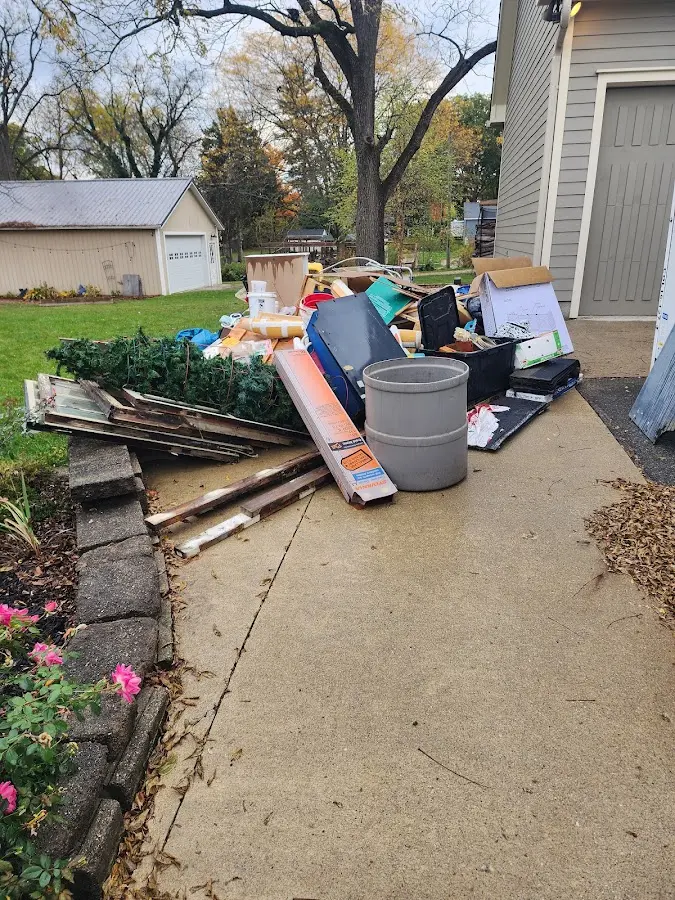 Dumpster being loaded with debris for 12 Yard Dumpster Rental in Maywood